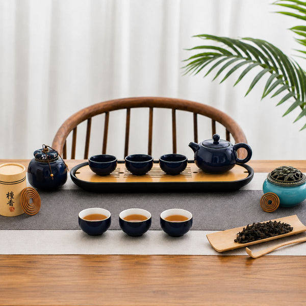 Jing midnight blue tea set arranged on a wooden tea tray with loose tea