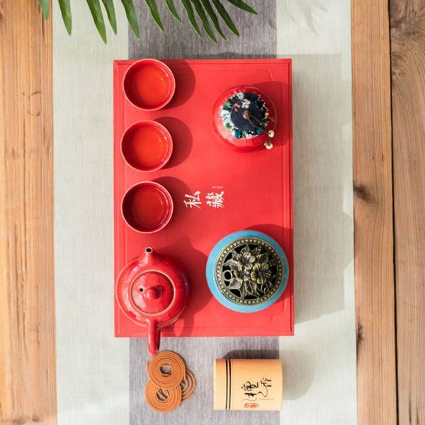 Overhead view of the Jing red tea set arranged on a red serving tray