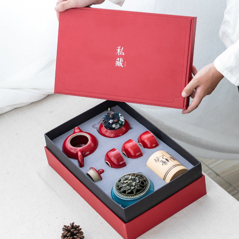 Red gift box being opened on the Jing red porcelain tea set