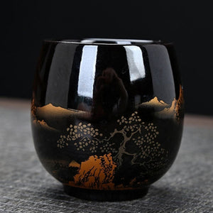 Kumo black ceramic tea cup with gold landscape design