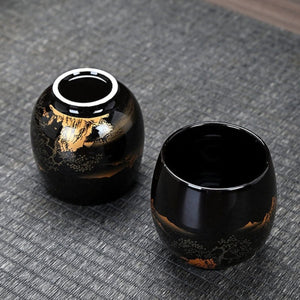 Two Kumo black ceramic tea cups showing the base and the glazed interior