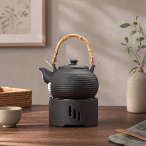 Nagi matte black clay teapot resting on its candle warmer
