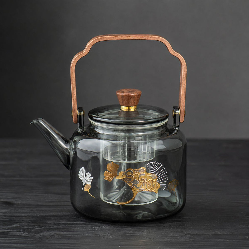 Reika smoked glass teapot with walnut handle and gold ginkgo motif on dark wood