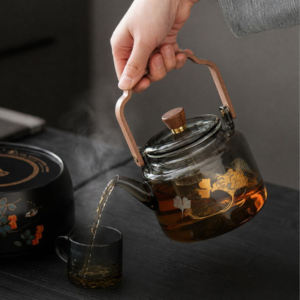 Reika glass teapot pouring brewed tea into a matching smoked glass cup