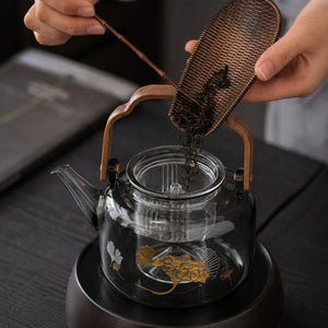 Loose tea leaves poured into the removable glass infuser of the Reika glass teapot