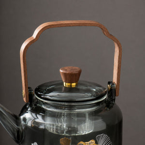 Close-up of the Reika teapot walnut handle, brass fittings and glass lid knob
