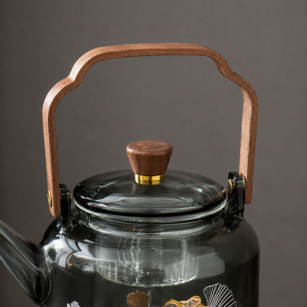 Close-up of the Reika teapot walnut handle, brass fittings and glass lid knob