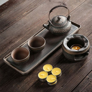 Top view of the Renji pottery tea set with lit warmer and four tealight candles