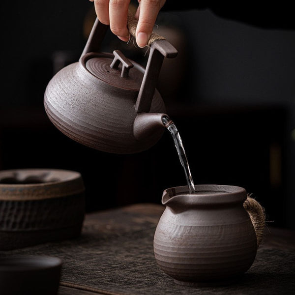 Pouring tea from the Sumi ceramic teapot into a fairness pitcher