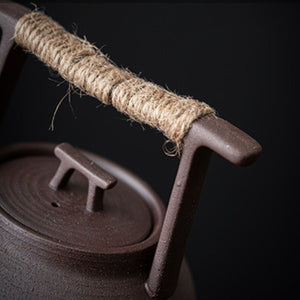 Close-up of the rope-wrapped handle and lid knob of the Sumi ceramic teapot