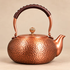 Varen 1.8L hammered copper kettle with wrapped handle on a plain background