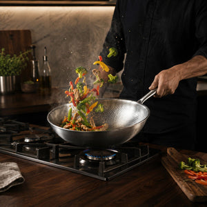 Vegetables tossed mid-air from the titanium wok over a gas flame