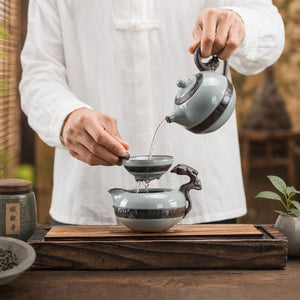 Tea poured from the Yunlong ceramic teapot through the strainer into the fair cup